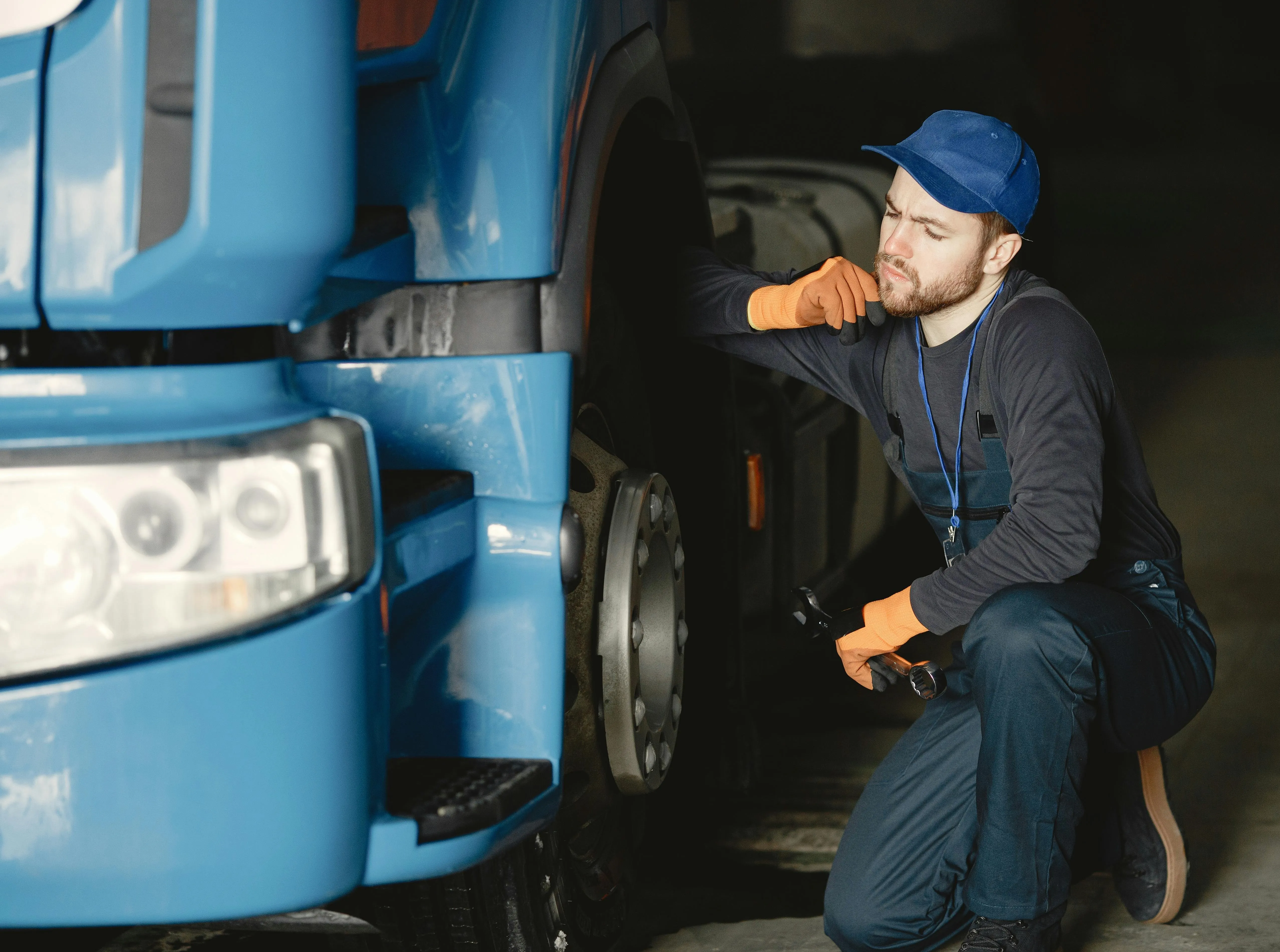 A thoughtful truck driver holding a wrench, planning how to fix the truck issue